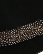 Close-up view of a black teardrop crown fedora with a speckled black and white feather hat band and burnt brim edge
