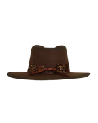 Back view of a dark brown wide-brim fedora with an teardrop crown crease and layered rust-tone feather hat band.