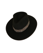 Three-quarter angled top view of a black teardrop crown fedora with a speckled black and white feather hat band and burnt brim edge

